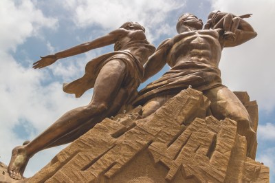 Large monument of a man, woman, and child pointing up to the sky