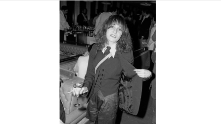 Black-and-white image of a young woman holding a drink